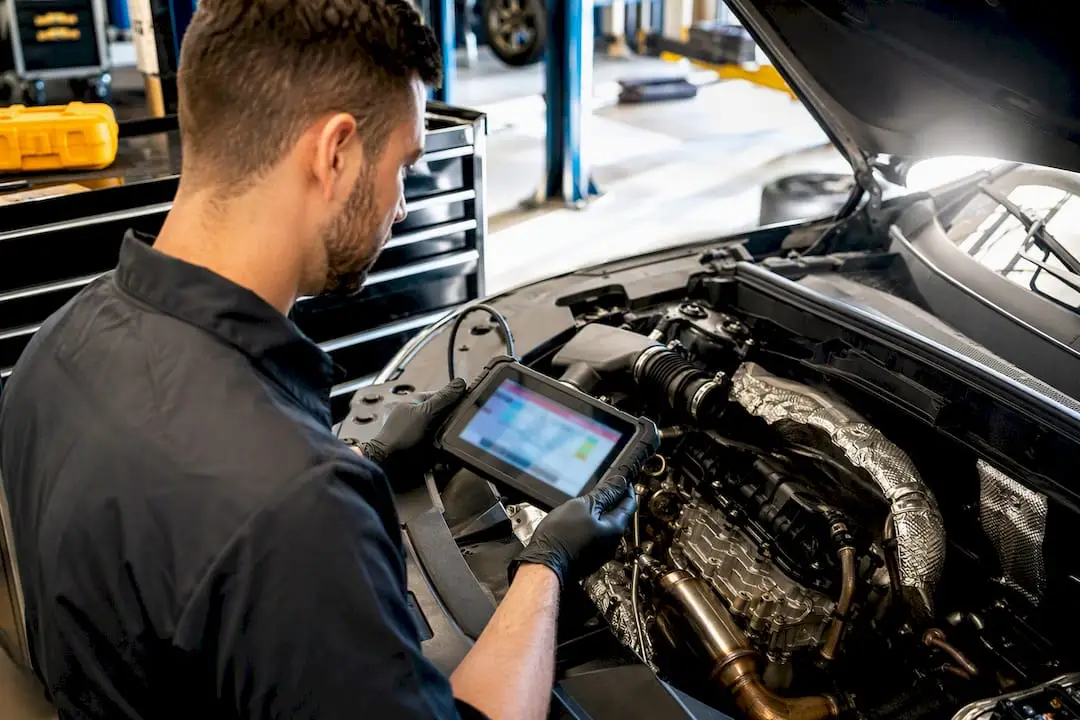 Technician diagnosing vehicle emissions system
