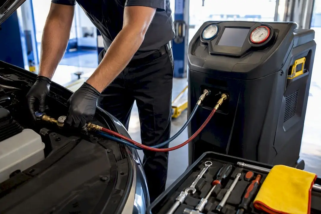 Technician using AC recovery equipment