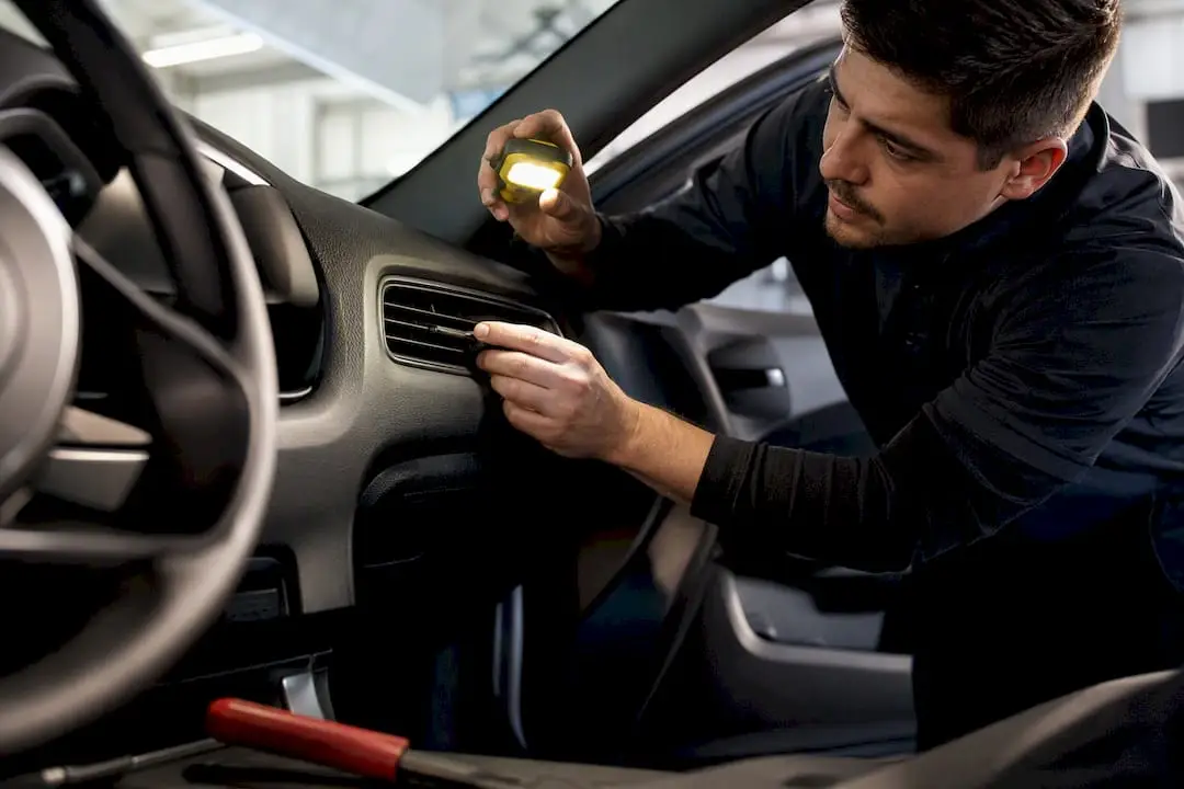 Technician checking vehicle AC airflow
