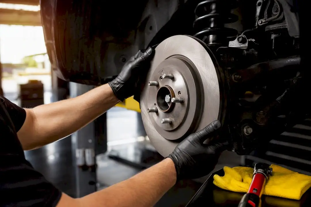 Technician installing brake rotor in service bay