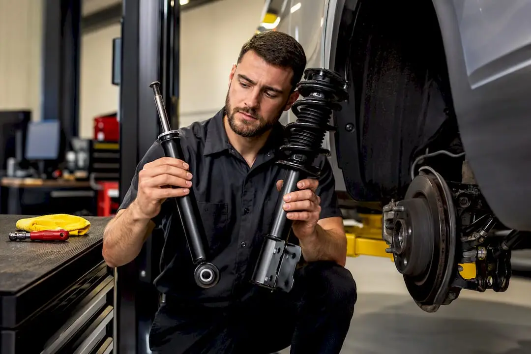 Technician comparing shock and strut components